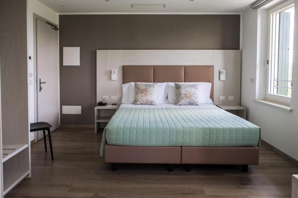 a bedroom with a large bed and a window at Albergo Ristorante Belvedere in Tricesimo