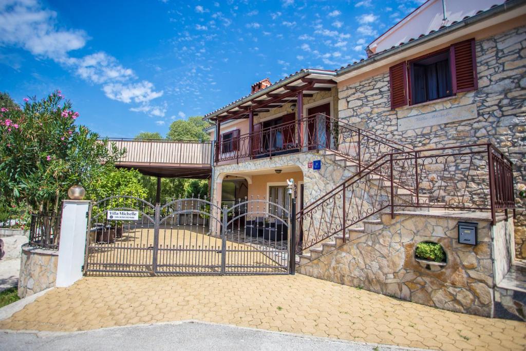 a house with a gate and a balcony at Villa Michelle in Karojba