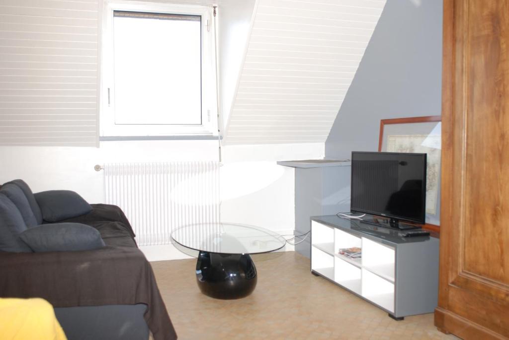 ein Wohnzimmer mit einem Sofa und einem TV auf dem Tisch in der Unterkunft Studio le Sterne in Perros-Guirec