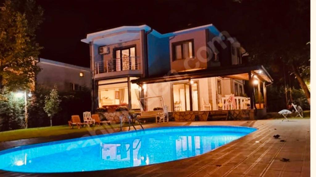 een huis met een zwembad in de nacht bij Bahçe'de Villa in Sapanca