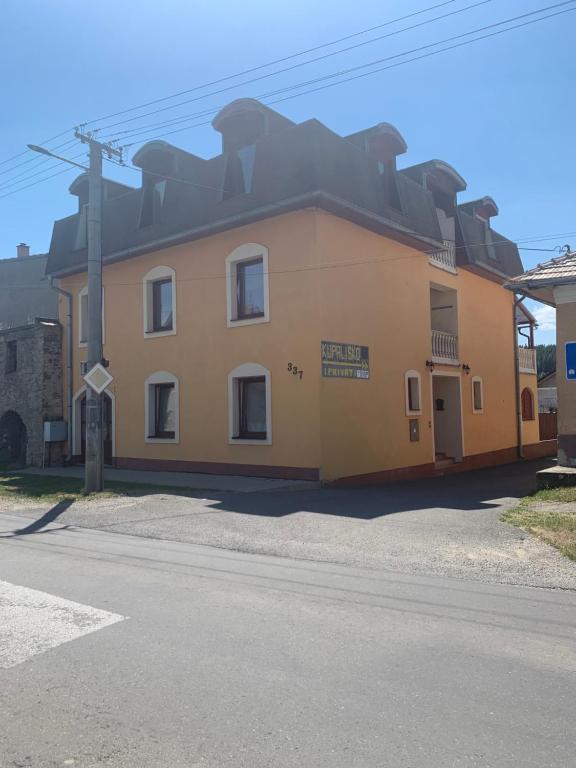 a yellow building on the side of a street at apartmánový dom Magda in Vrbov