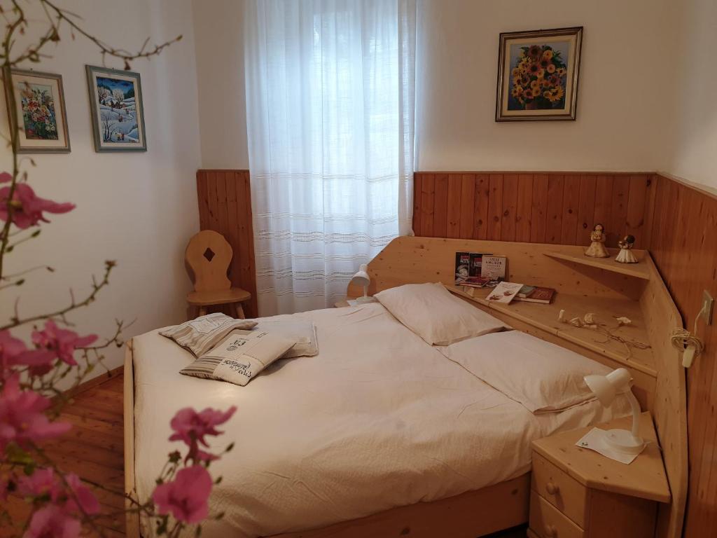 ein Schlafzimmer mit einem großen Bett mit einem Holzrahmen in der Unterkunft Bed & Breakfast LA BETULLA in Baselga di Pinè