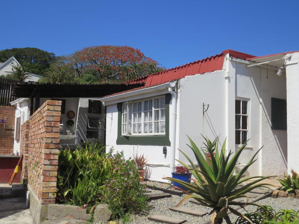 a white house with a red roof at Wiltshire Cottage in Port Alfred