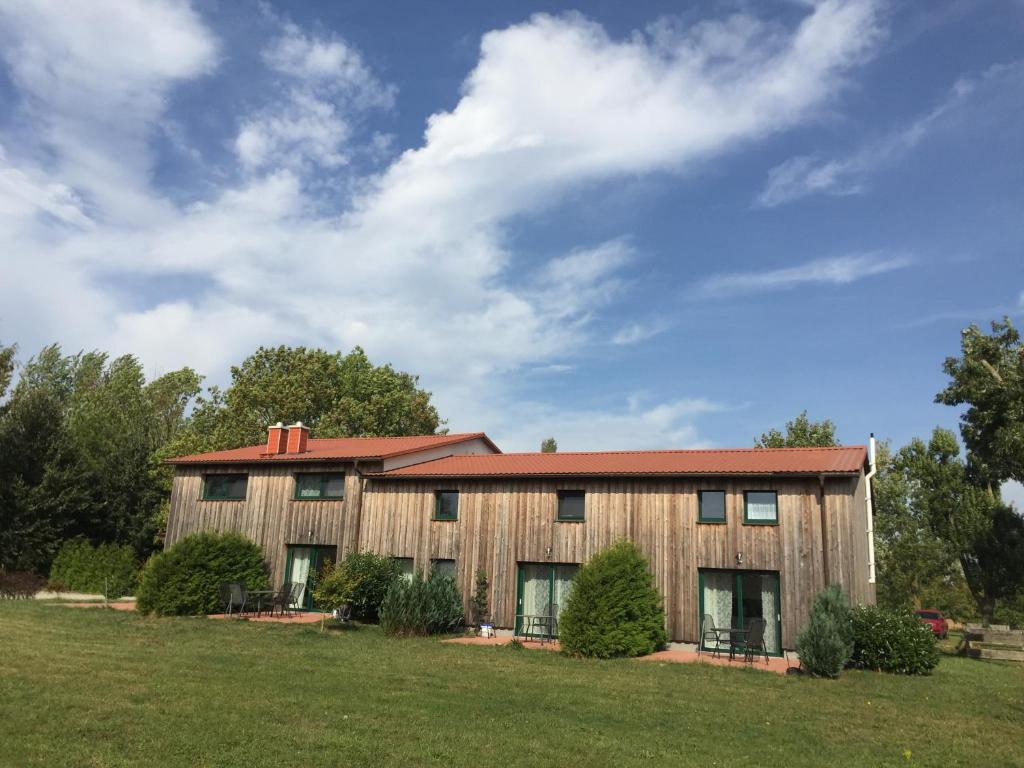 a large wooden building with a red roof at Haus Dreischläfer deluxe in Dreschvitz