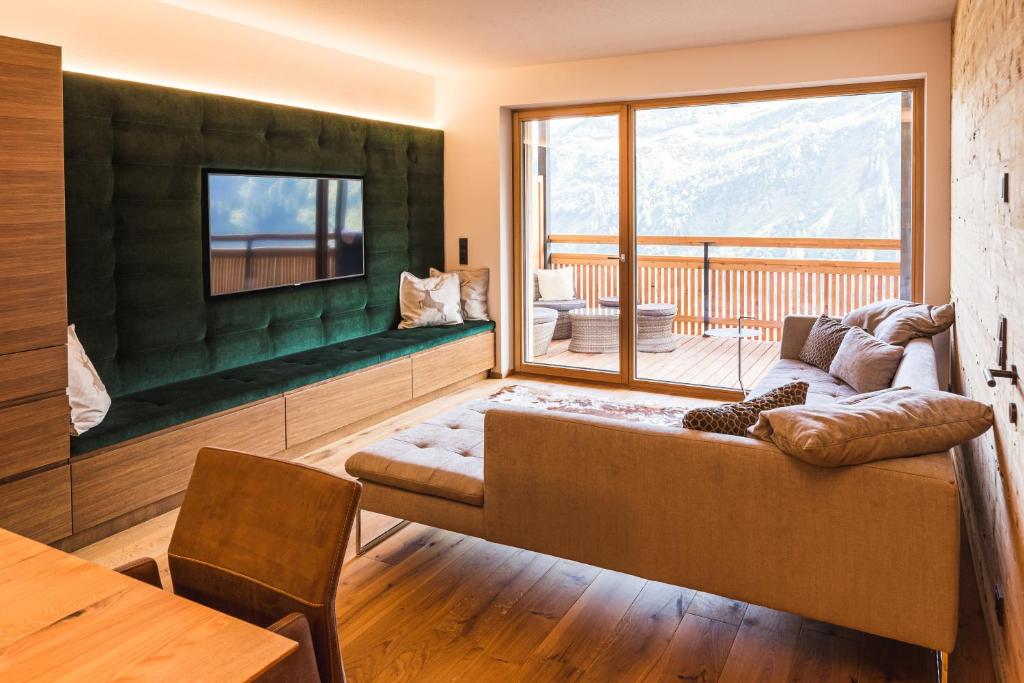 uma sala de estar com um sofá e uma grande janela em Landhaus Bergblicksuite TOP11 em Damüls