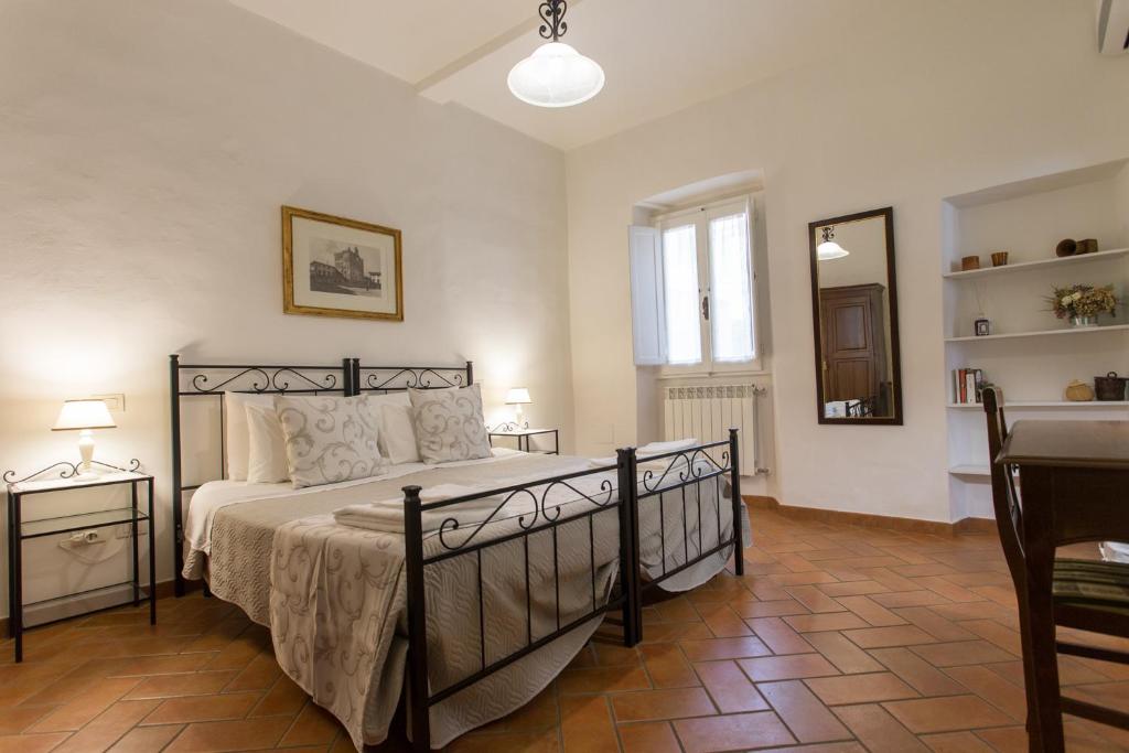 Datini Apartment في براتو: غرفة نوم بسرير وطاولة ومرآة