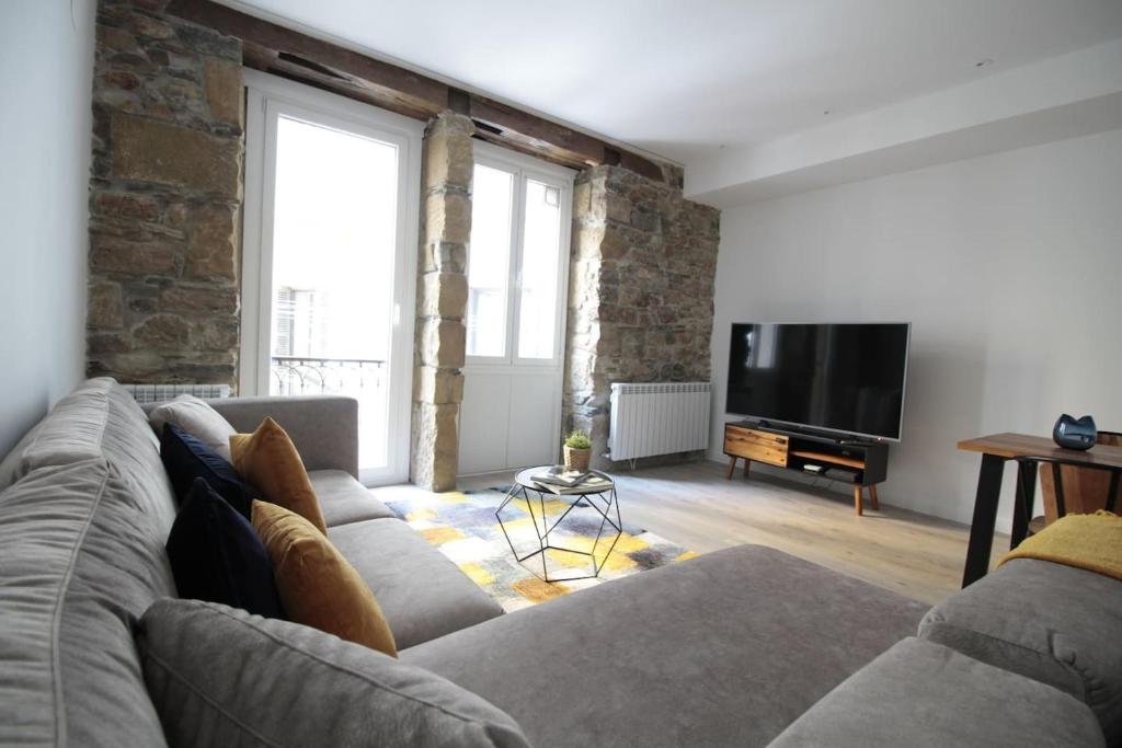 un soggiorno con divano e TV a schermo piatto di SunSet Bastian Apartment a San Sebastián
