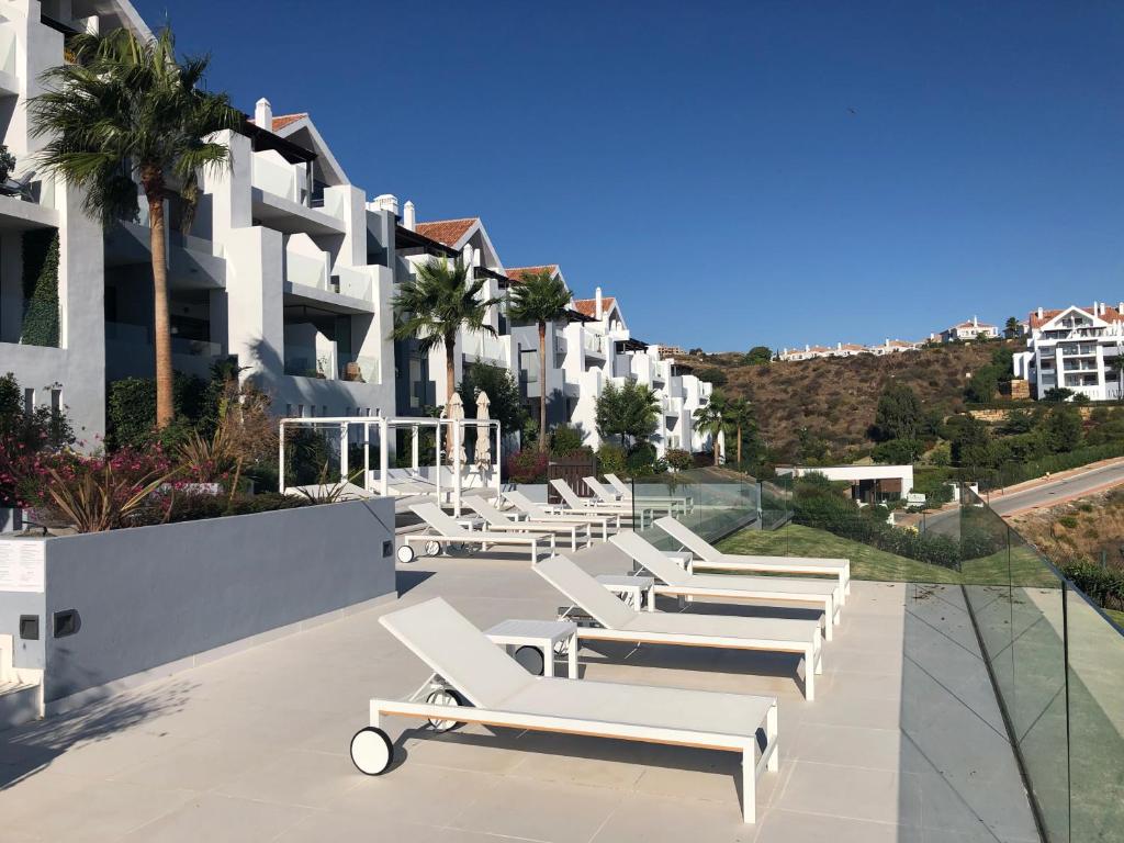 a row of chaise lounges on a patio at a resort at LA CALA HILL CLUB (LOS CORTIJOS) in La Cala de Mijas