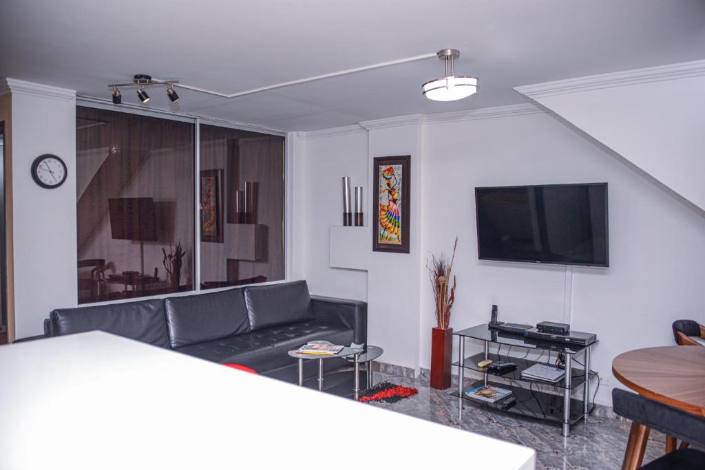 Apartment Carrera 301 في ميديلين: غرفة معيشة مع أريكة وتلفزيون