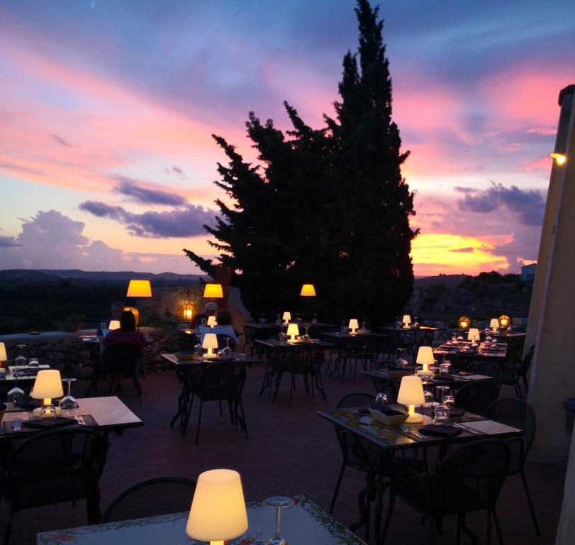 a restaurant with tables and chairs at sunset at Hotel La Corte Del Sole in Noto