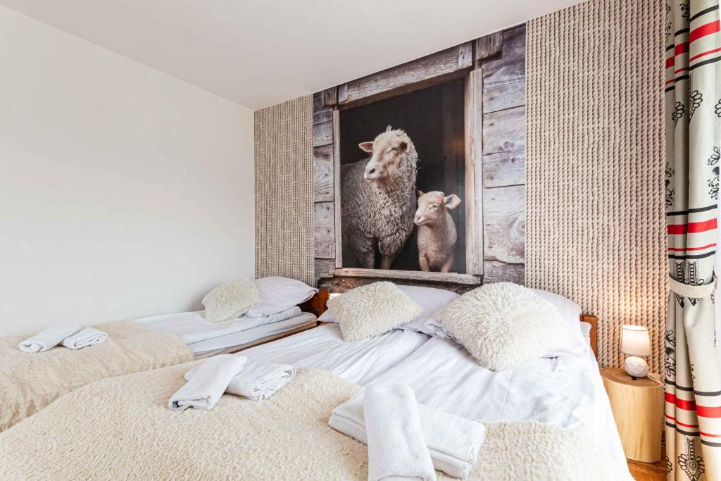 a bedroom with two beds and a picture of a sheep at Gronik in Groń