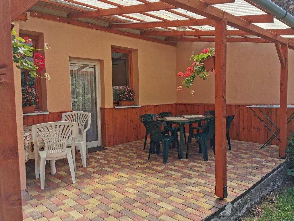 eine Terrasse mit einem Tisch und Stühlen darauf in der Unterkunft Kis Rigó vendégház in Salgótarján