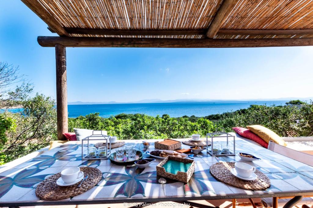 mesa de comedor con vistas al océano en su mari su entu Isola di Sant'Antioco villa con accesso diretto al mare en SantʼAntioco Ponti