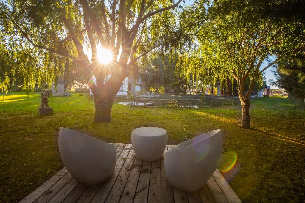 dos sillas blancas sentadas en una mesa en un parque en Mar & Campo en Santa Teresita
