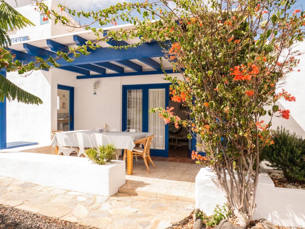 a patio with a table and a tree with flowers at Timfay in Corralejo