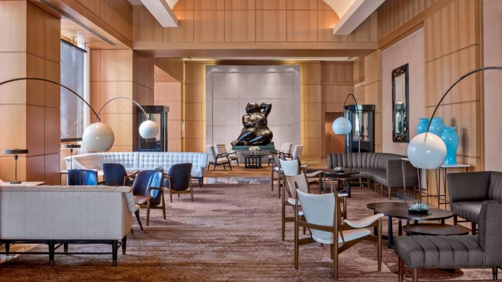 a lobby with tables and chairs and a dog statue at Private condo hotel at Four Seasons Brickell in Miami