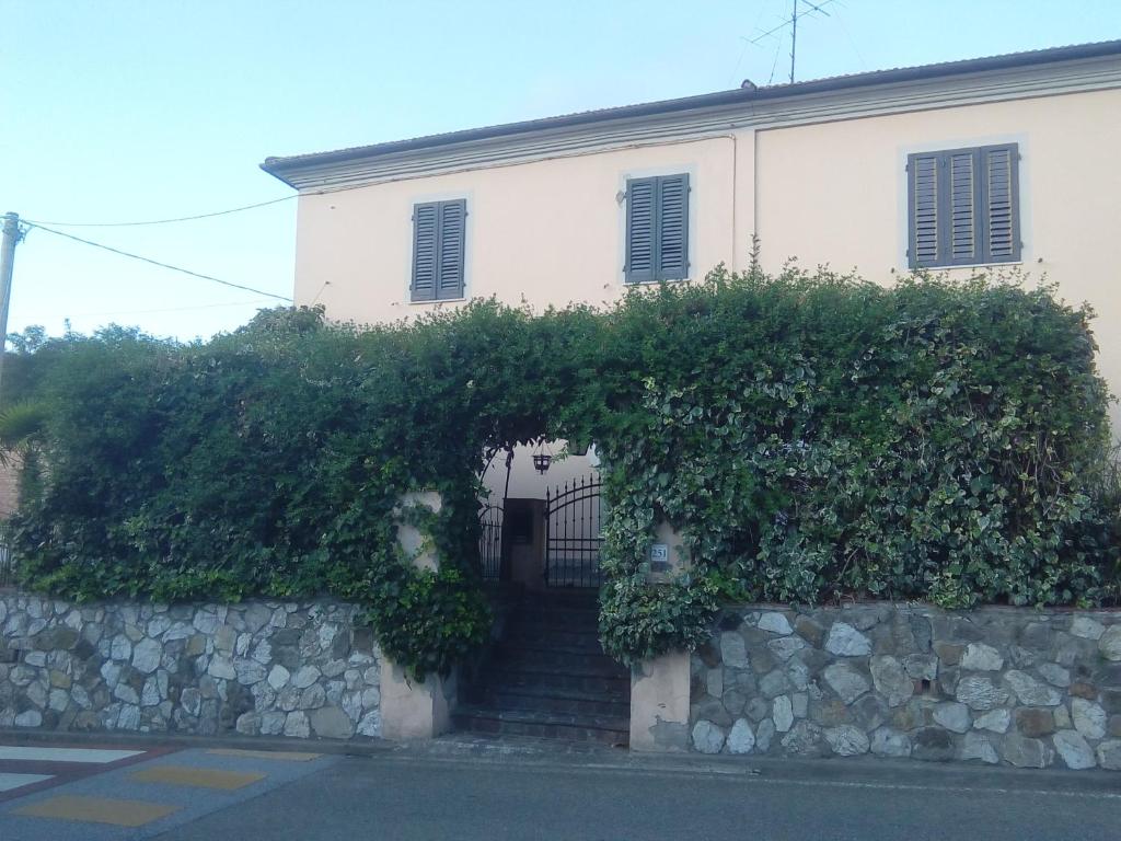 a building with a stone wall and stairs in front at Terre di creta...per sognare in Pomaia