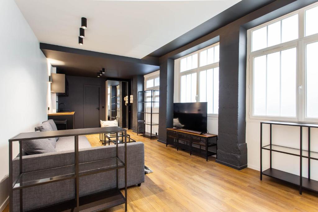 uma sala de estar com uma cama e uma televisão em Dreamyflat - loft opera em Paris