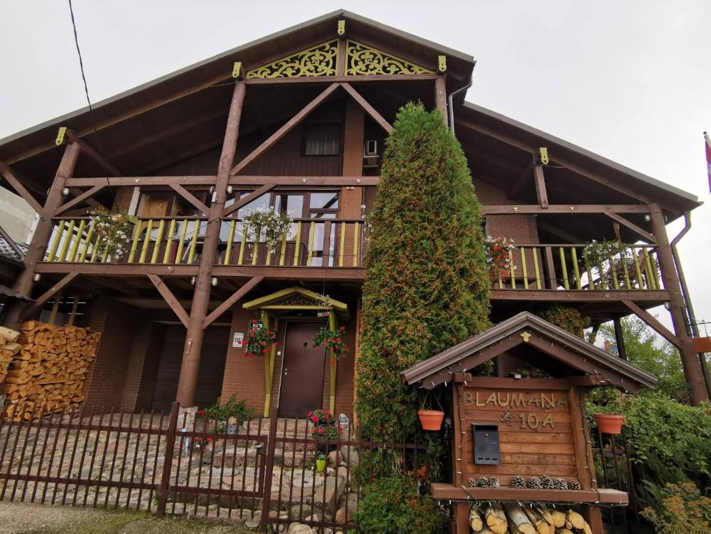 a wooden house with a balcony and a fence at GARDEN CHALET in Daugavpils