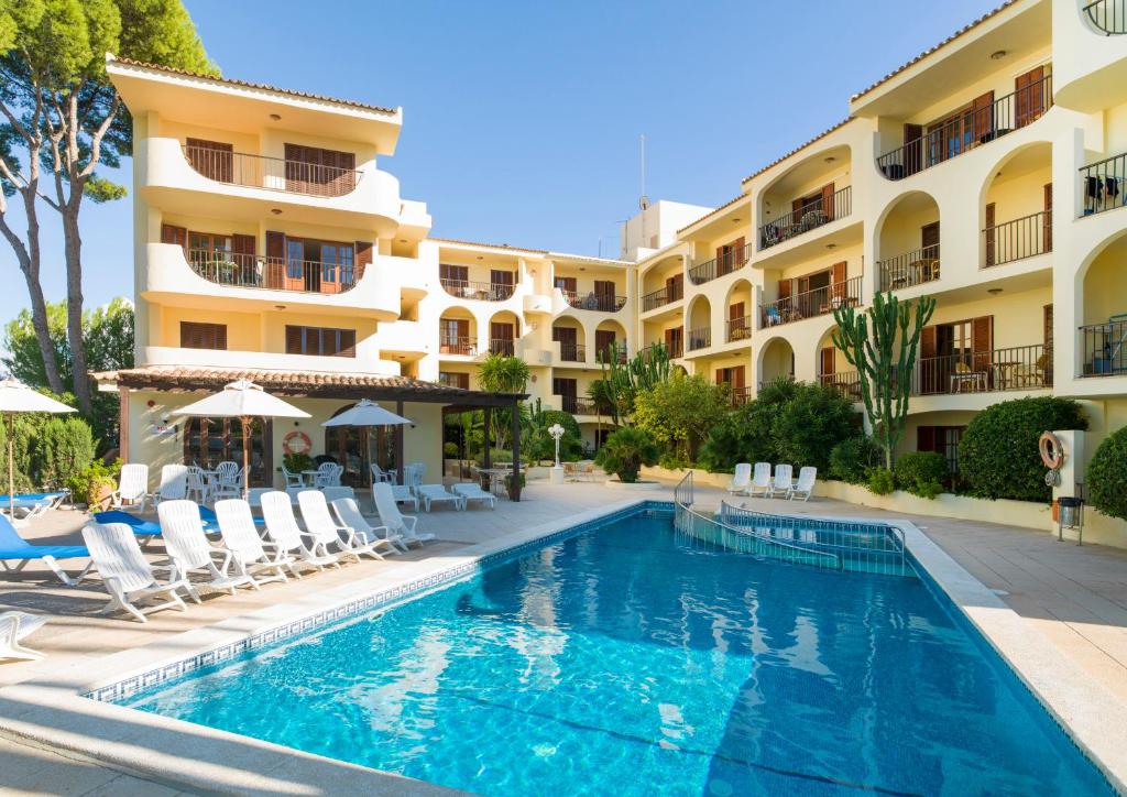 un hotel con piscina frente a un edificio en Apartamentos Casa Vida, en Santa Ponsa