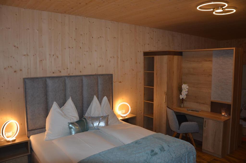 a bedroom with a large bed with a desk and a bed sidx sidx at Harrauer´s Living in Erlauf