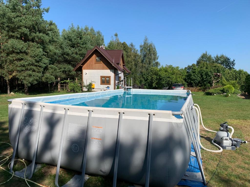 a swimming pool in a yard next to a house at Pod Papugami in Laskowice