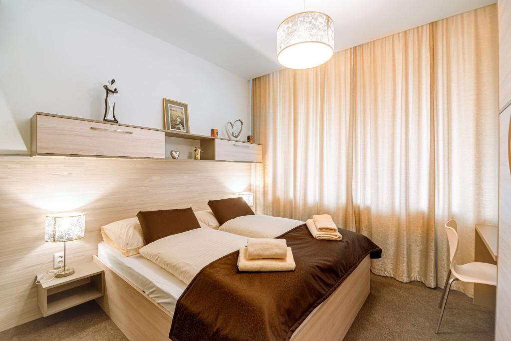 a bedroom with a bed with two towels on it at Apartment Elegance Hrebienok in Smokovce