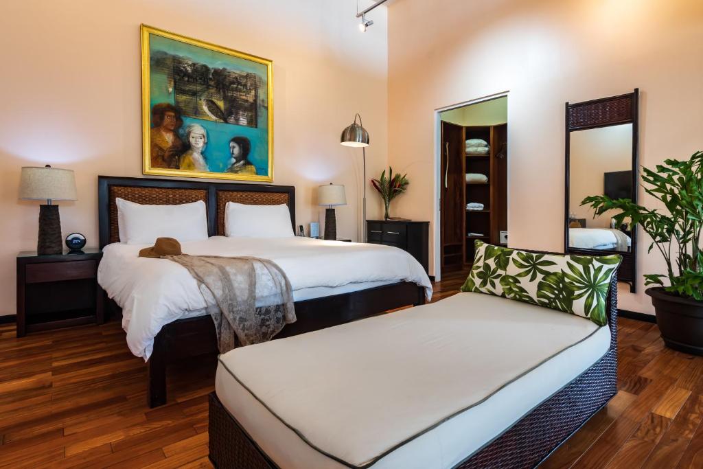 Habitación de hotel con 2 camas y sofá en Gaia Hotel & Reserve- Adults Only, en Manuel Antonio