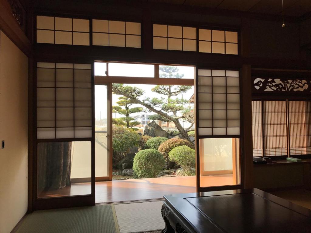 a room with an open door to a garden at Y House in Kurashiki