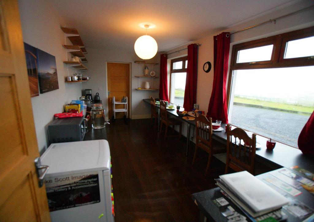 a kitchen and dining room with a table and chairs at Sona Baile Home Stay in Dooagh