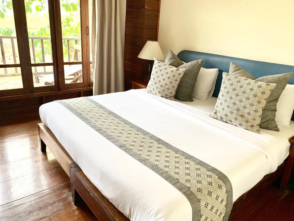 
A bed or beds in a room at Riverhouse Hotel (The Teak House)
