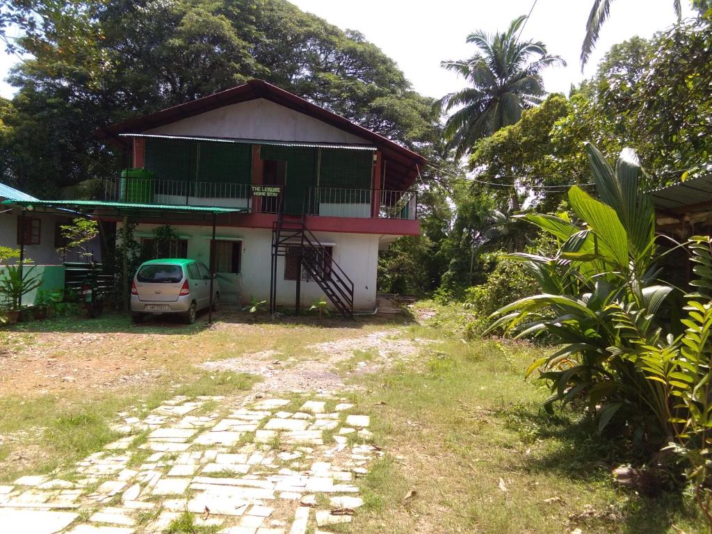 una casa con un coche aparcado delante de ella en The Leisure Home Stay, en Shādipur