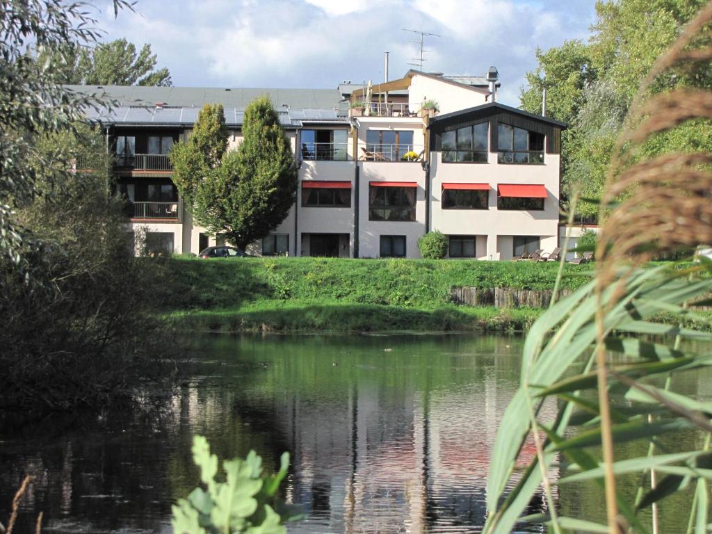 a building next to a river in front of a building at Hotel Le Caballin in Vogelgrun