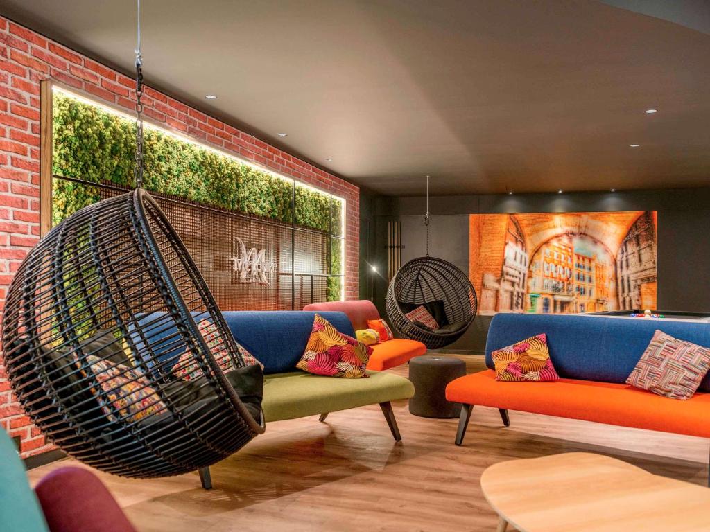 a living room with a couch and a swing at Hotel Mercure Toulouse Centre Compans in Toulouse