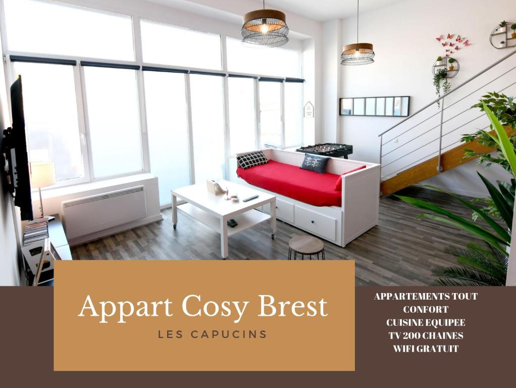 Appart Cosy Brest (les Capucins) في بريست: شقة مريحة مع أريكة حمراء وطاولة
