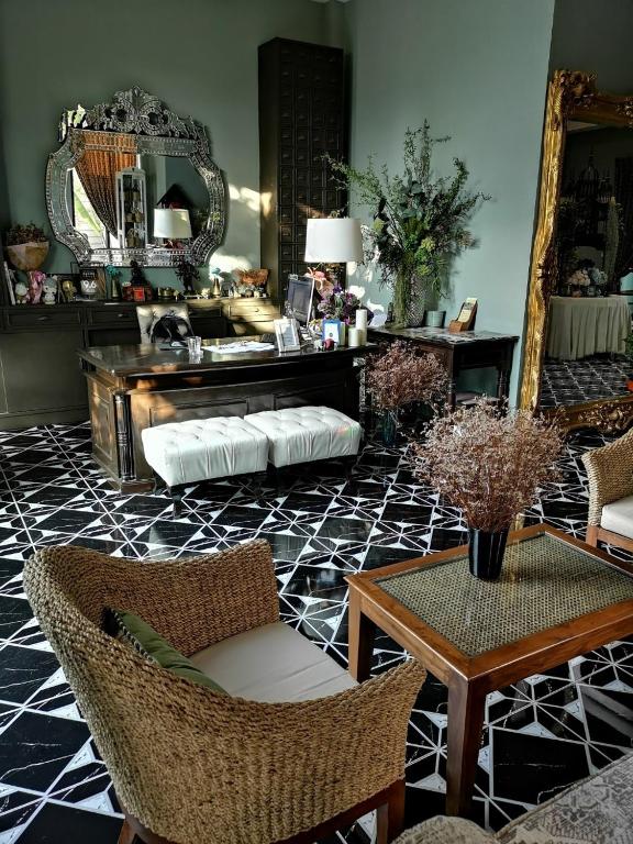 a living room with a table and chairs and a mirror at Sri Ngachang in Chiang Mai