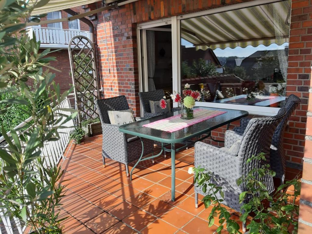 a patio with a table and chairs on a deck at Bei Bille und Jan in Bad Bentheim