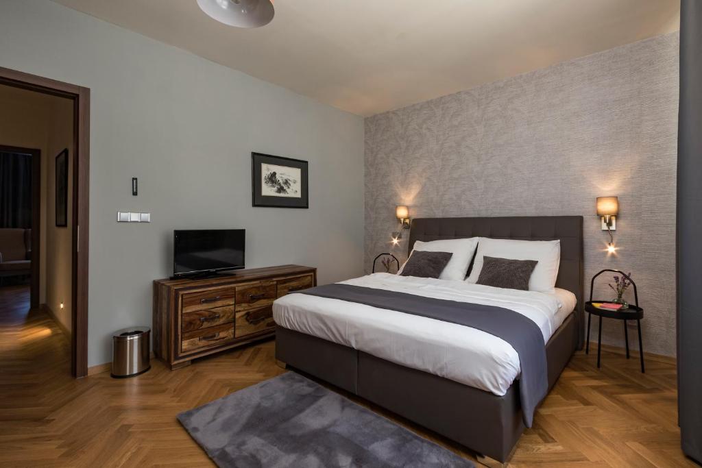 um quarto com uma cama grande e uma televisão em Areal Botanika em Unhošť