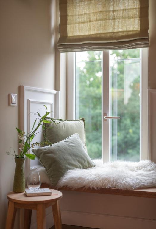 a window seat with a white pillow and a table at Konrads Limburg - Hotel &amp; Gästehaus in Limburg an der Lahn