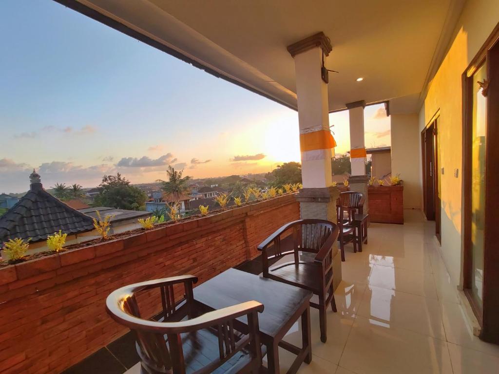 a balcony with chairs and a view of the sunset at Kubu Taman Home Stay in Ubud