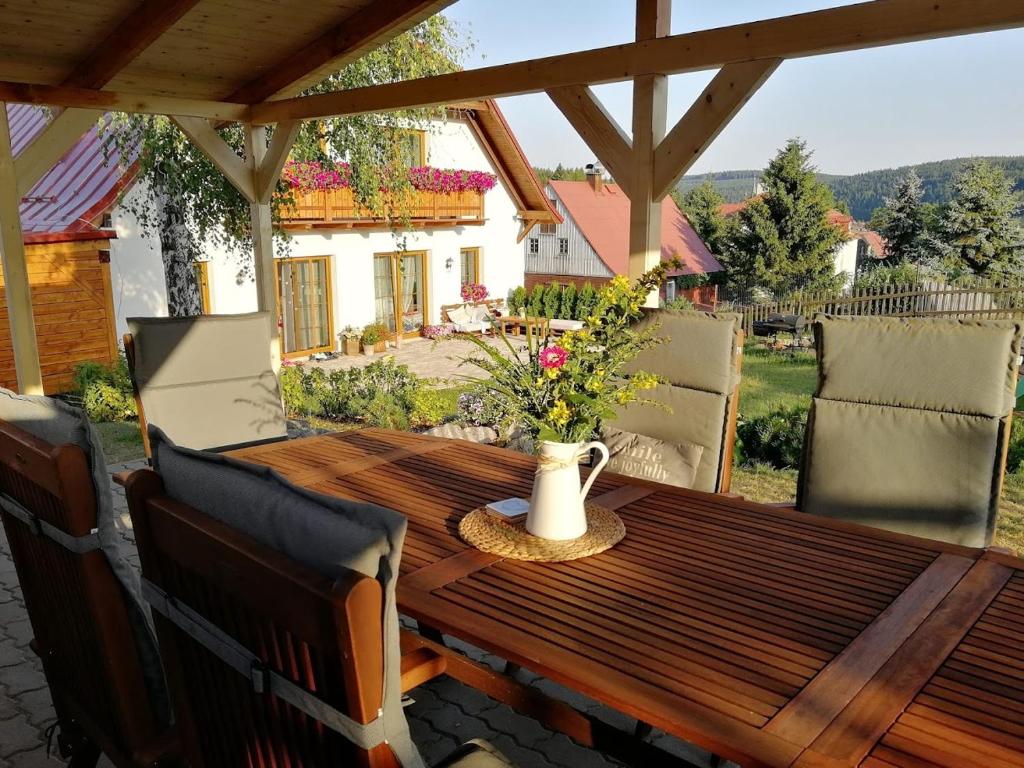 a wooden table with chairs on a patio at Pension MAX in Pernink