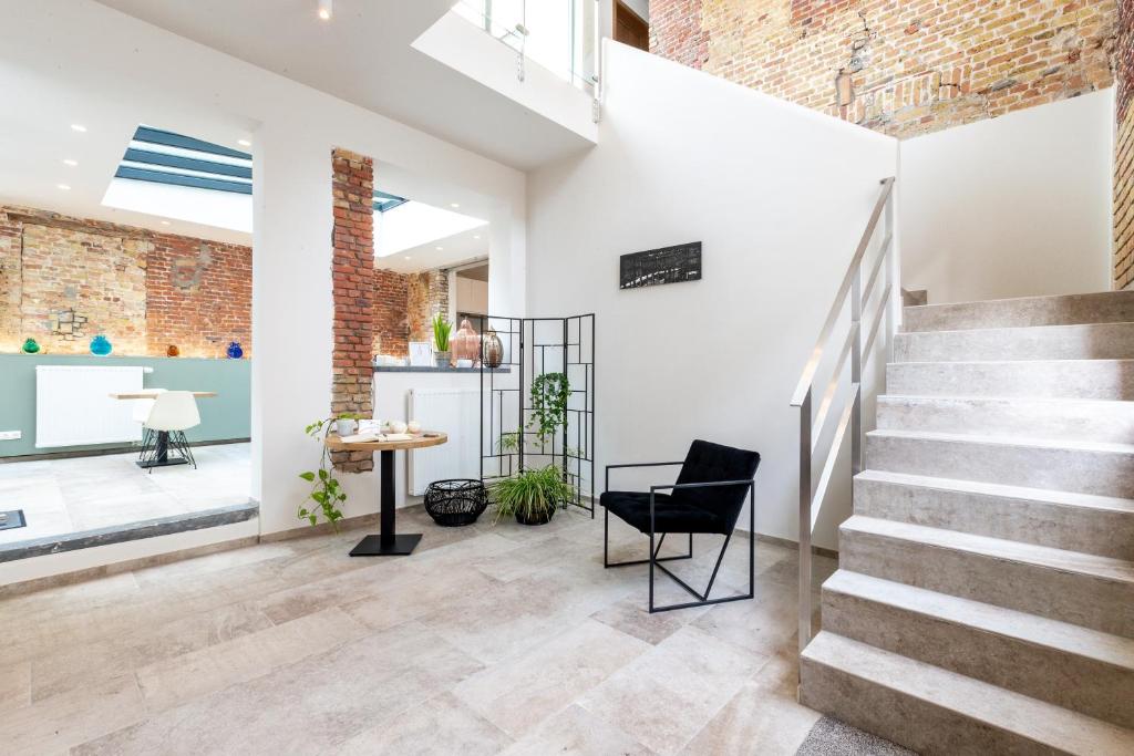 a room with stairs and a table and a chair at La Clé Brugge in Bruges