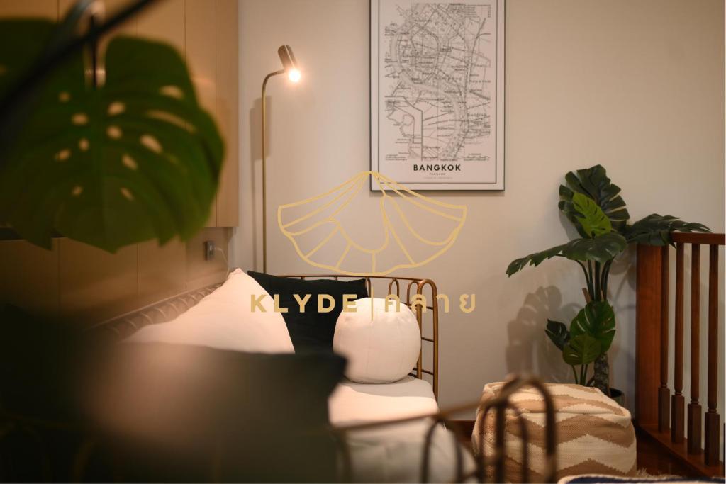 a room with a bed and a plant and a lamp at KLYDE Boutique - Chatuchak in Bangkok