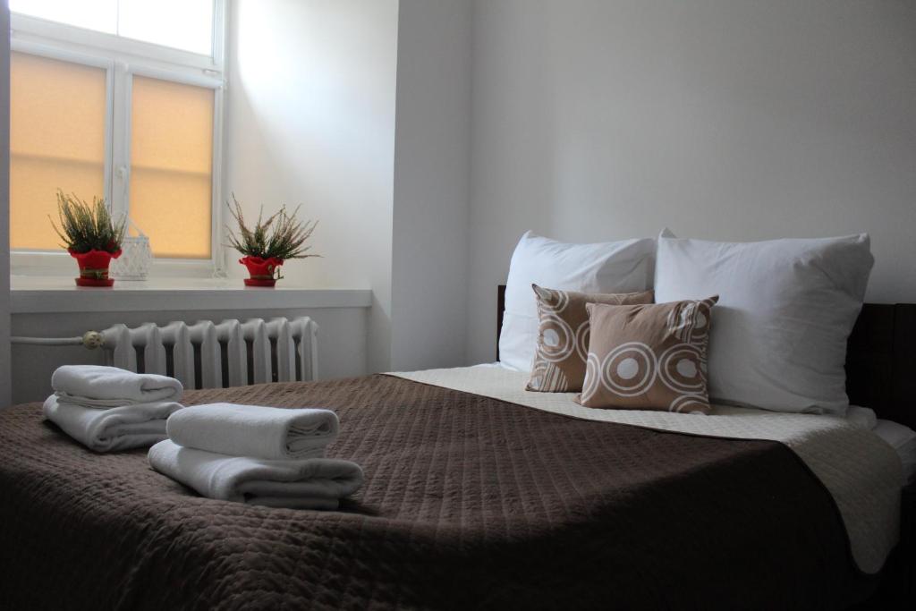 una camera da letto con un letto e asciugamani di M&M apartamenty a Zamość