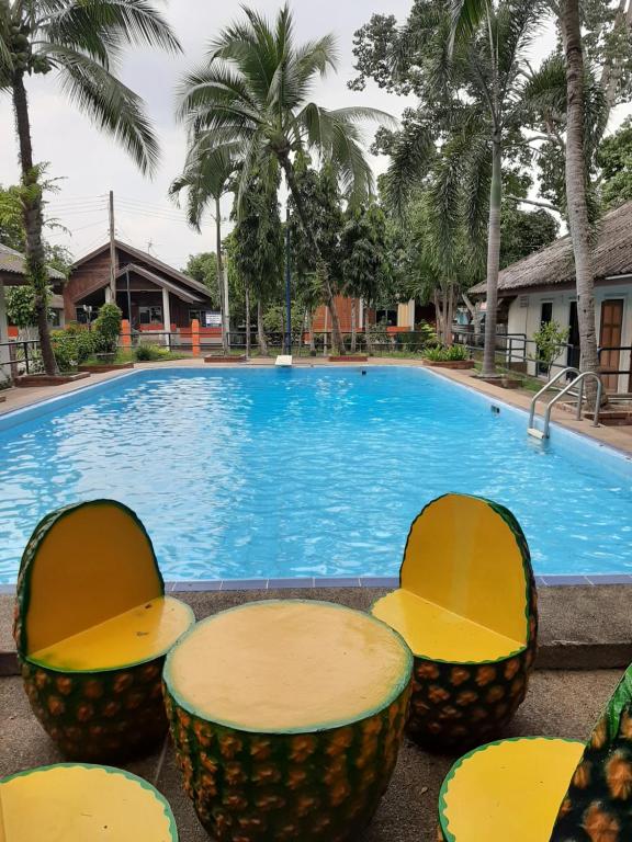 una piscina con sillas y mesas frente a un complejo en จักรดาว เมาท์เท่น วิว (Mountain View) en Ban Nong Saeng (4)