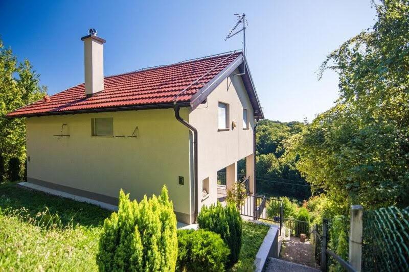 uma pequena casa branca com um telhado vermelho em Kuća za odmor Nature em Cerje