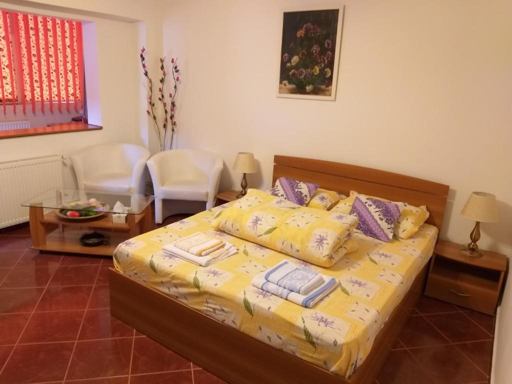 a bedroom with a bed with yellow sheets and pillows at Apartament Rebeca in Braşov