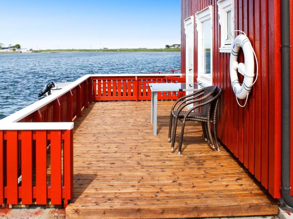 uma doca com uma mesa e cadeiras num barco em 6 person holiday home in Brekstad em Brekstad