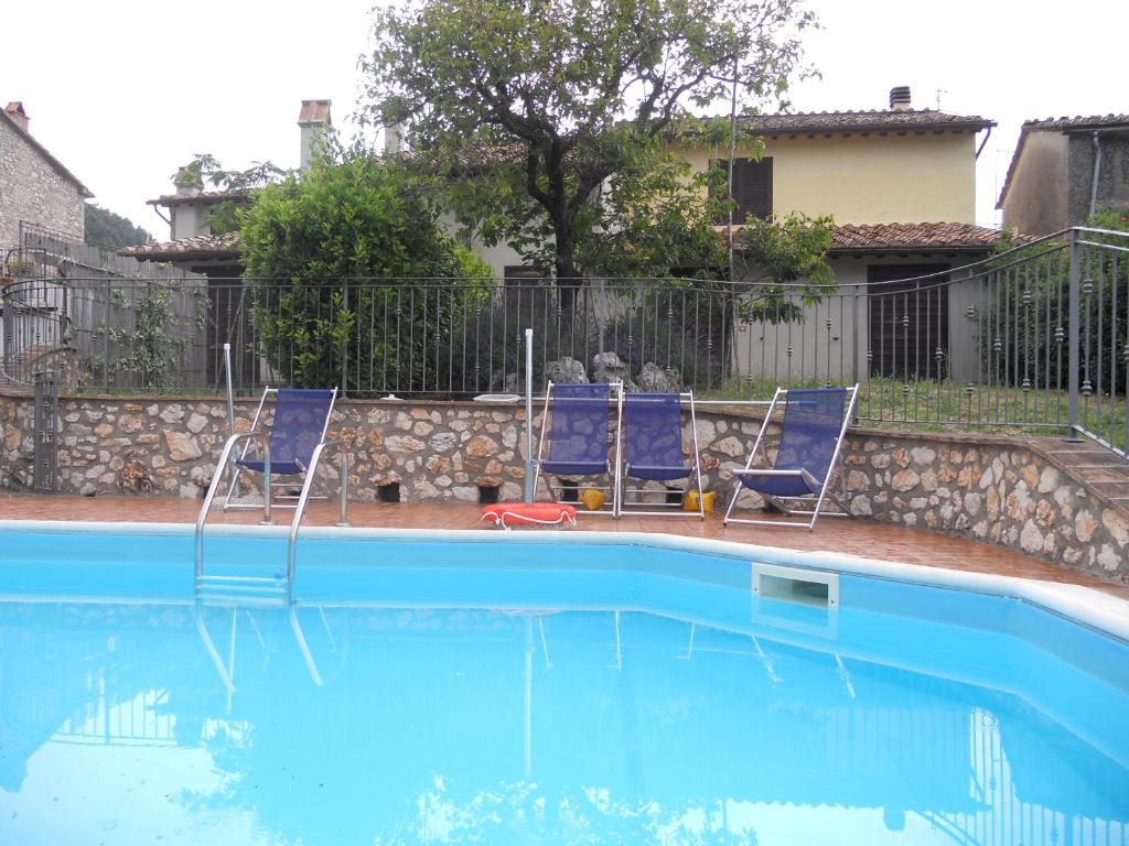 2 sillas azules sentadas junto a una piscina en La Fattoria Di Mamma Ro', en Narni
