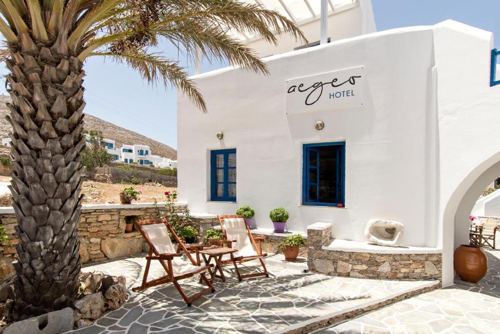 a large white building with palm trees at Aegeo Hotel in Chora Folegandros